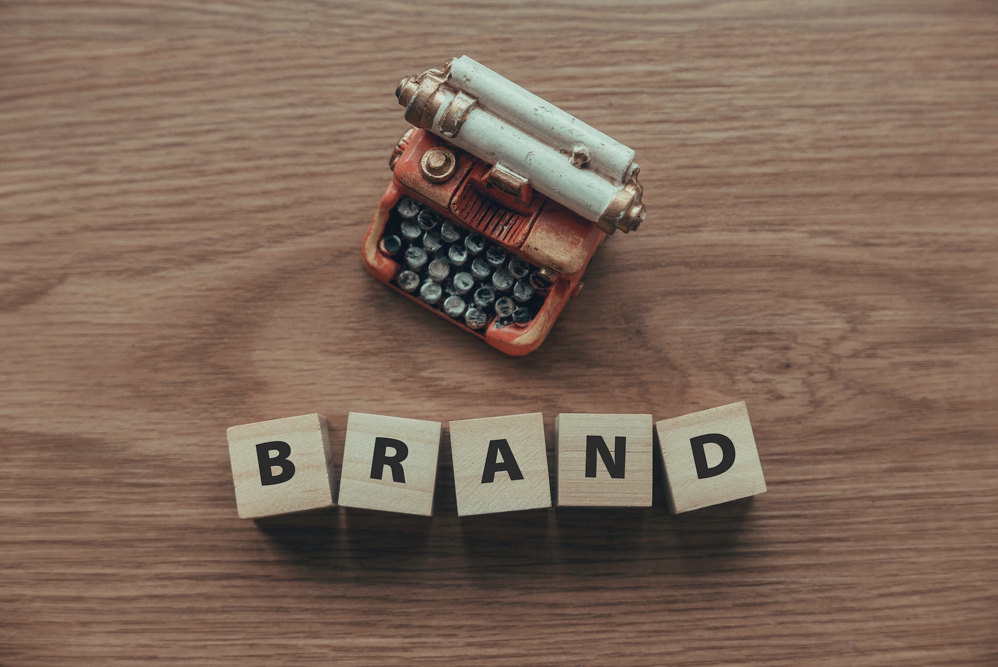 top-view-of-typewriter-and-wooden-cube-with-text-brand-on-wooden-background-.jpg